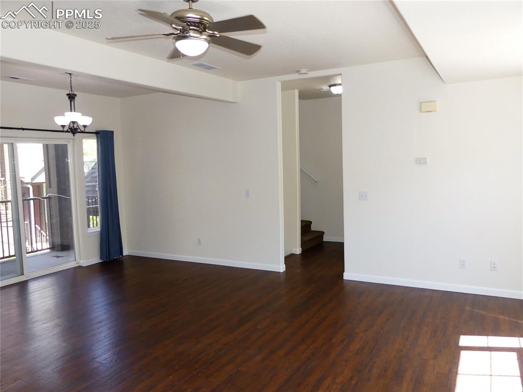 1054 Kara Ridge Point Colorado Springs, CO 80907 - Photo 5 of 33 Dining room with baseboards, wood finished floors, stairway, and ceiling fan with notable chandelier