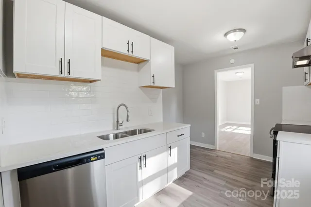 a kitchen with a sink cabinets and wooden floor