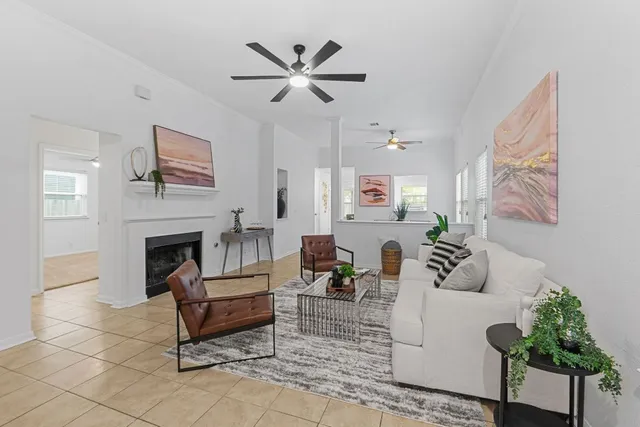 a living room with furniture a fireplace and a large window