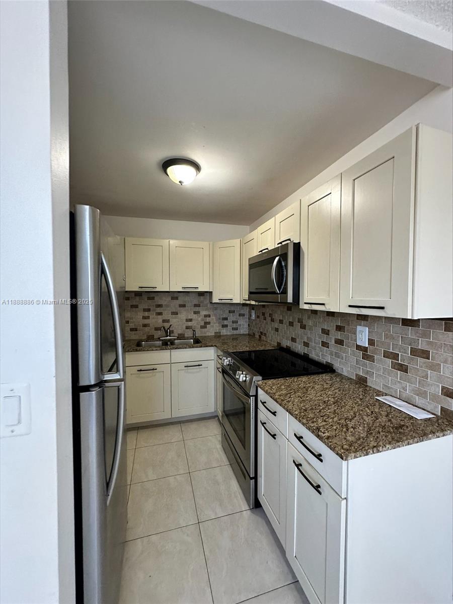6214 Southwest 131st Court, Unit 201 Miami, FL 33183 - Photo 11 of 18 a kitchen with a sink stove and refrigerator