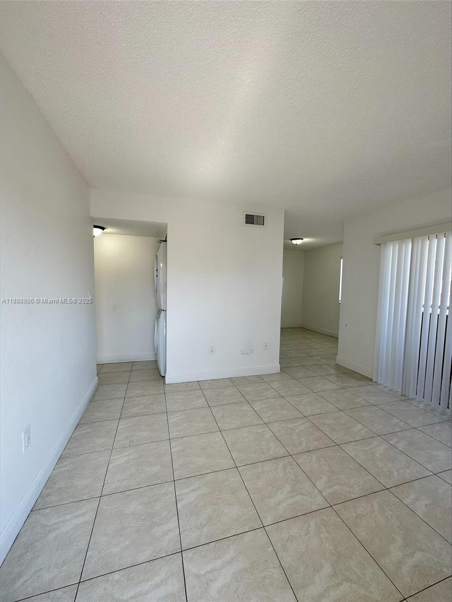 6214 Southwest 131st Court, Unit 201 Miami, FL 33183 - Photo 4 of 18 an empty room with white walls and tiles