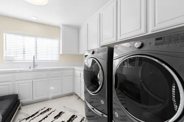 a utility room with sink dryer and washer