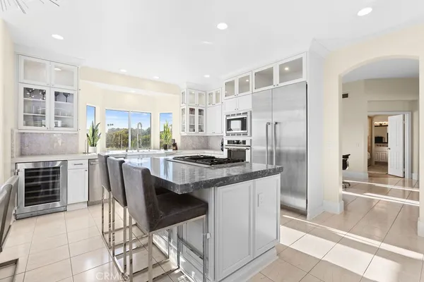 a kitchen with kitchen island a stove a refrigerator and a dining table with wooden floor