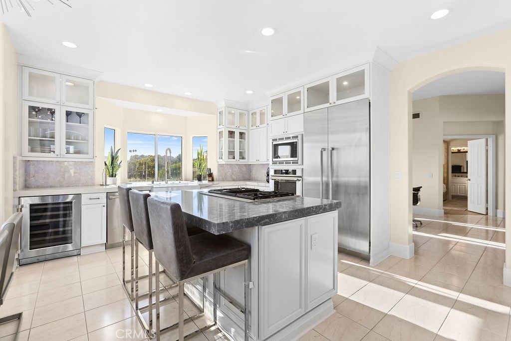 25352 Village Dana Point Dana Point, CA 92629 - Photo 6 of 41 a kitchen with kitchen island a stove a refrigerator and a dining table with wooden floor