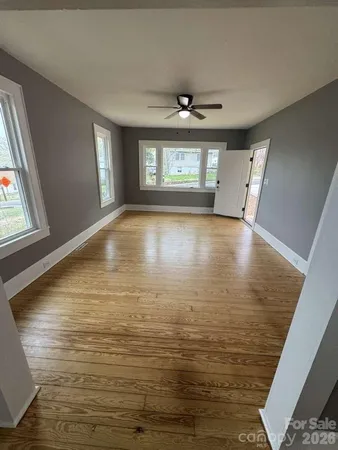 a view of empty room with window and wooden floor