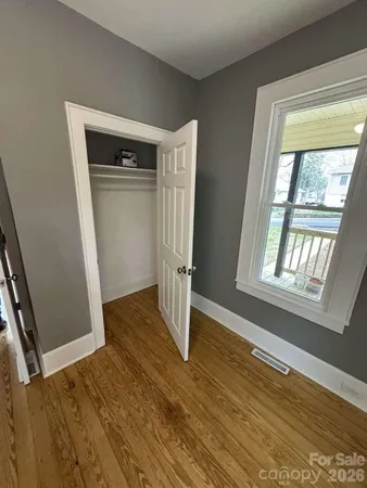 a view of empty room with wooden floor and window