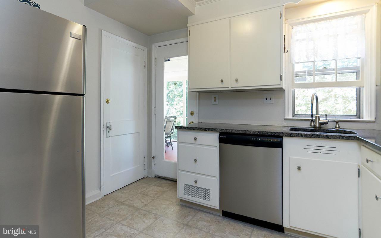 810 Olmstead Road Pikesville, MD 21208 - Photo 15 of 30 a kitchen with white cabinets and a refrigerator