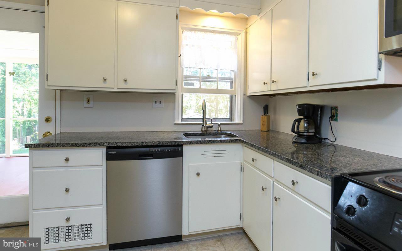 810 Olmstead Road Pikesville, MD 21208 - Photo 16 of 30 a kitchen with granite countertop white cabinets and a window