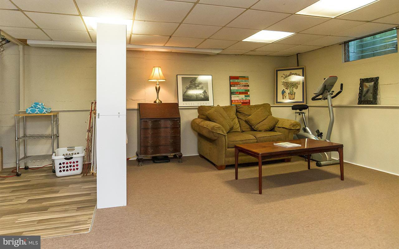 810 Olmstead Road Pikesville, MD 21208 - Photo 10 of 30 a living room with furniture a flat screen tv and a table