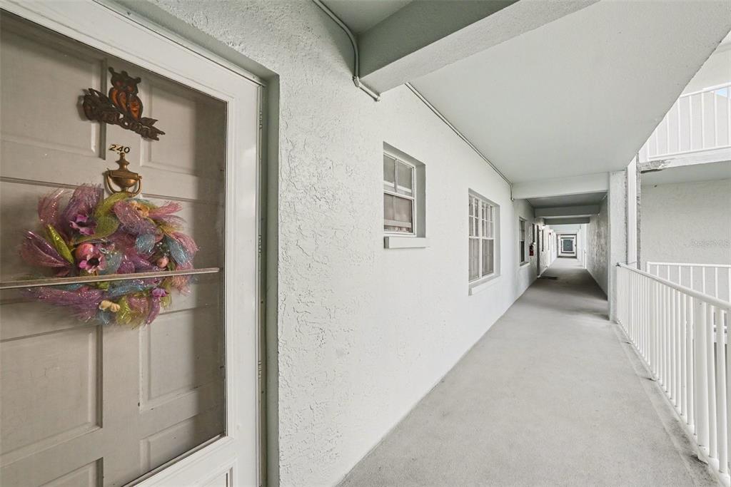 701 Poinsettia Road, Unit 240 Belleair, FL 33756 - Photo 11 of 30 a view of a hallway to a livingroom and a staircase