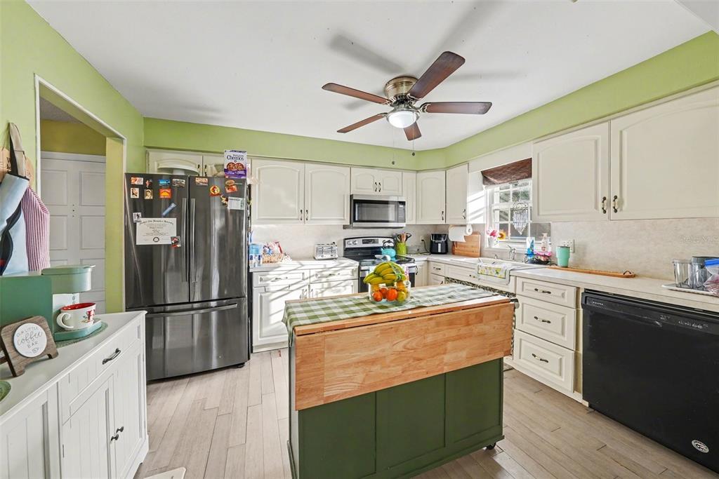 701 Poinsettia Road, Unit 240 Belleair, FL 33756 - Photo 12 of 30 a kitchen with stainless steel appliances granite countertop a refrigerator a sink dishwasher a stove and white cabinets with wooden floor