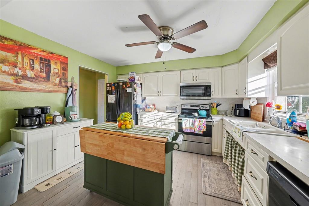 701 Poinsettia Road, Unit 240 Belleair, FL 33756 - Photo 13 of 30 a kitchen with stainless steel appliances kitchen island granite countertop a sink dishwasher stove and refrigerator with wooden floor
