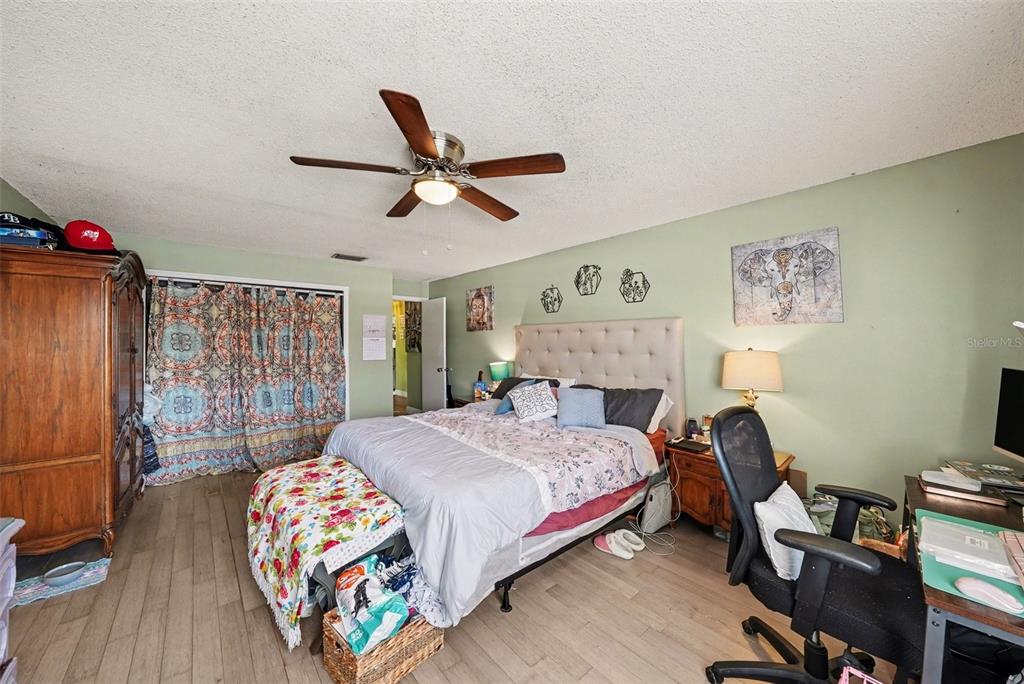 701 Poinsettia Road, Unit 240 Belleair, FL 33756 - Photo 16 of 30 a bedroom with a bed a dresser and a chandelier