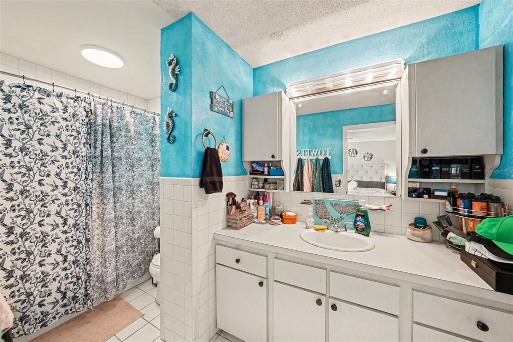 701 Poinsettia Road, Unit 240 Belleair, FL 33756 - Photo 18 of 30 a bathroom with a sink a mirror and shower