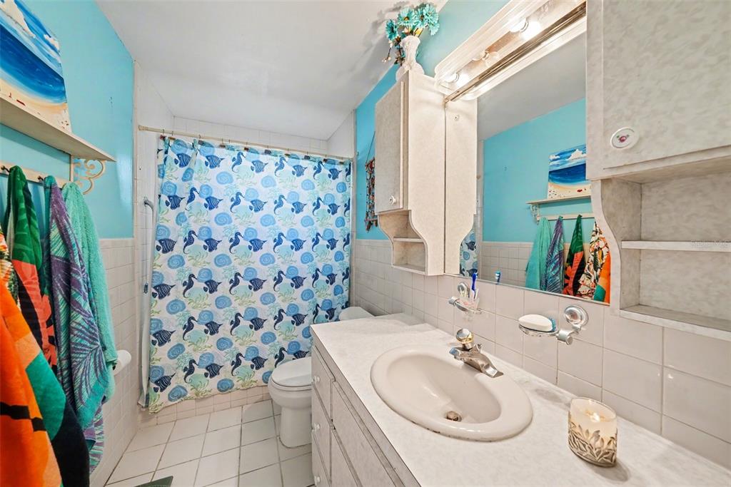 701 Poinsettia Road, Unit 240 Belleair, FL 33756 - Photo 3 of 30 a bathroom with a sink a toilet and shower curtain