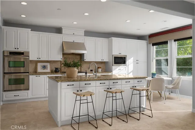 a kitchen with stainless steel appliances kitchen island granite countertop a stove a sink and a microwave