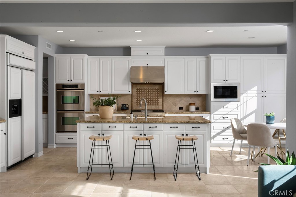 7 Waltham Road Ladera Ranch, CA 92694 - Photo 13 of 55 a kitchen with stainless steel appliances granite countertop a stove a sink a microwave a refrigerator and cabinets