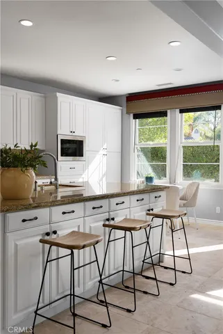 a kitchen with granite countertop a sink stove and cabinets