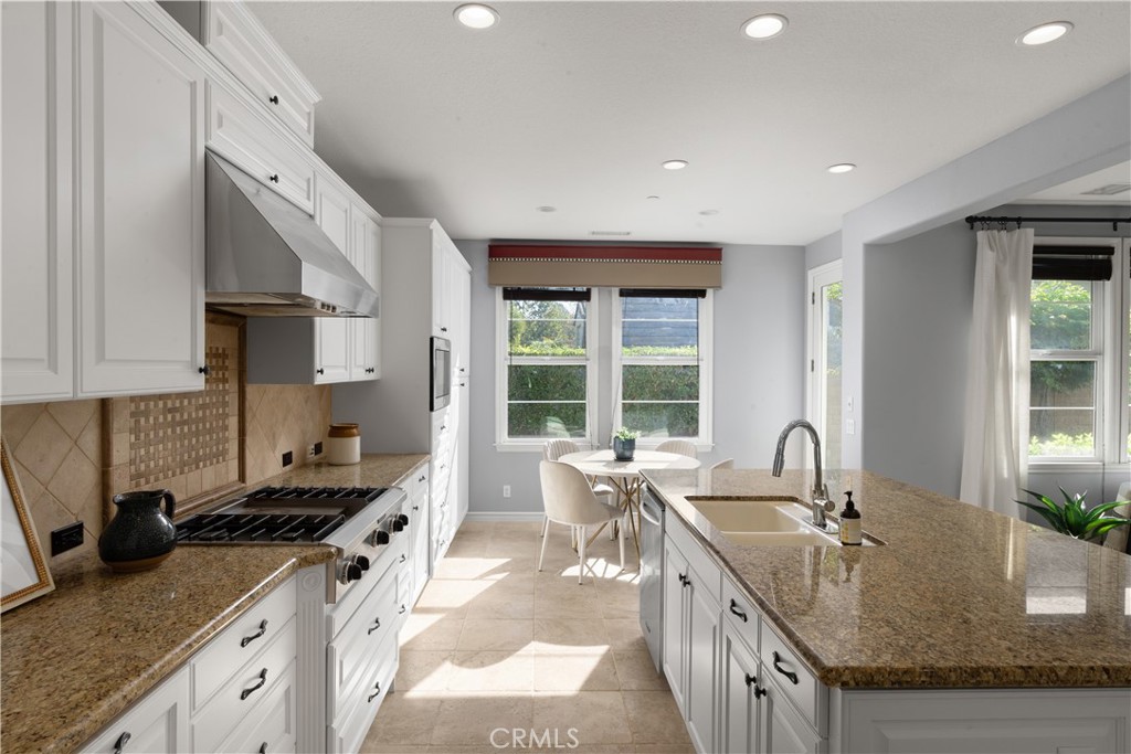7 Waltham Road Ladera Ranch, CA 92694 - Photo 22 of 55 a kitchen with granite countertop a sink stove and cabinets