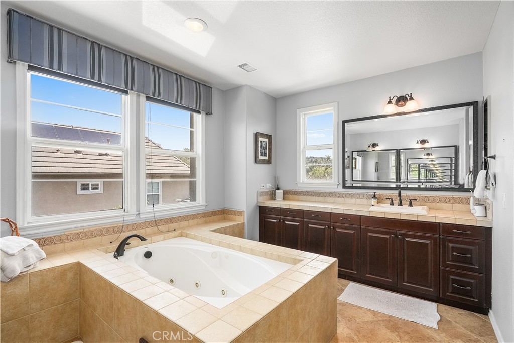 7 Waltham Road Ladera Ranch, CA 92694 - Photo 46 of 55 a bathroom with a tub sink double vanity and window