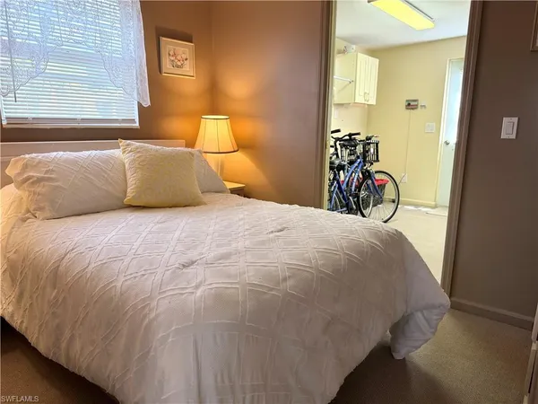 a bed sitting in a bedroom next to a window