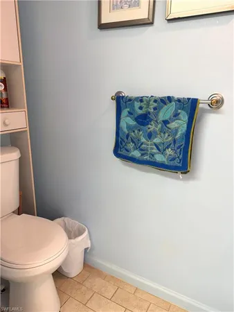 a white toilet sitting next to a white wall