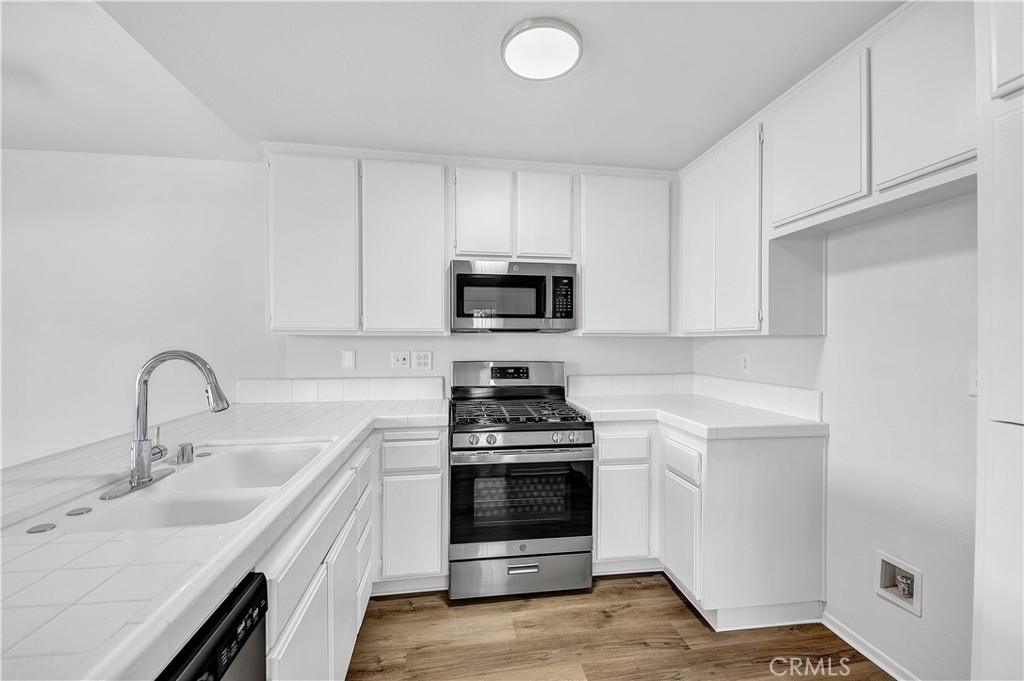 27042 Rangewood Street Menifee, CA 92586 - Photo 12 of 22 a kitchen with sink a microwave and cabinets
