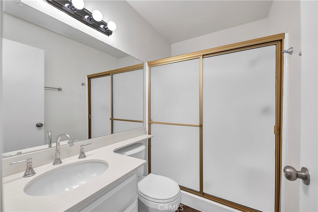 27042 Rangewood Street Menifee, CA 92586 - Photo 16 of 22 a bathroom with a sink mirror vanity and toilet