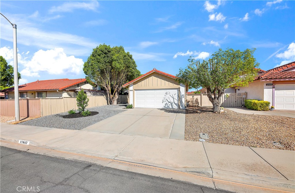 27042 Rangewood Street Menifee, CA 92586 - Photo 3 of 22 a view of a house with a yard and garage