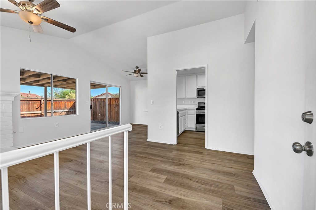 27042 Rangewood Street Menifee, CA 92586 - Photo 8 of 22 a view of a livingroom with wooden floor and a ceiling fan
