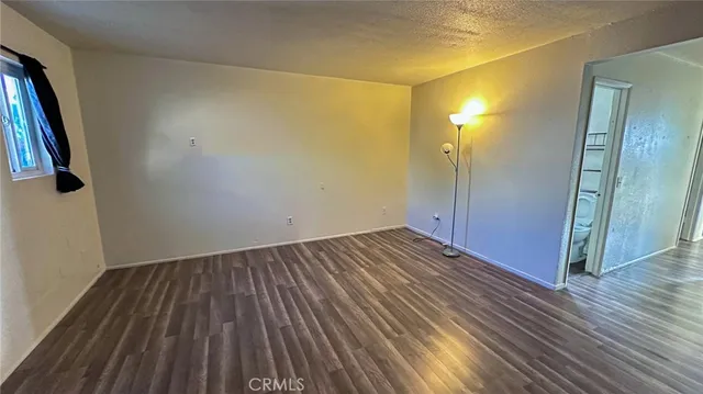 an empty room with wooden floor and entrance