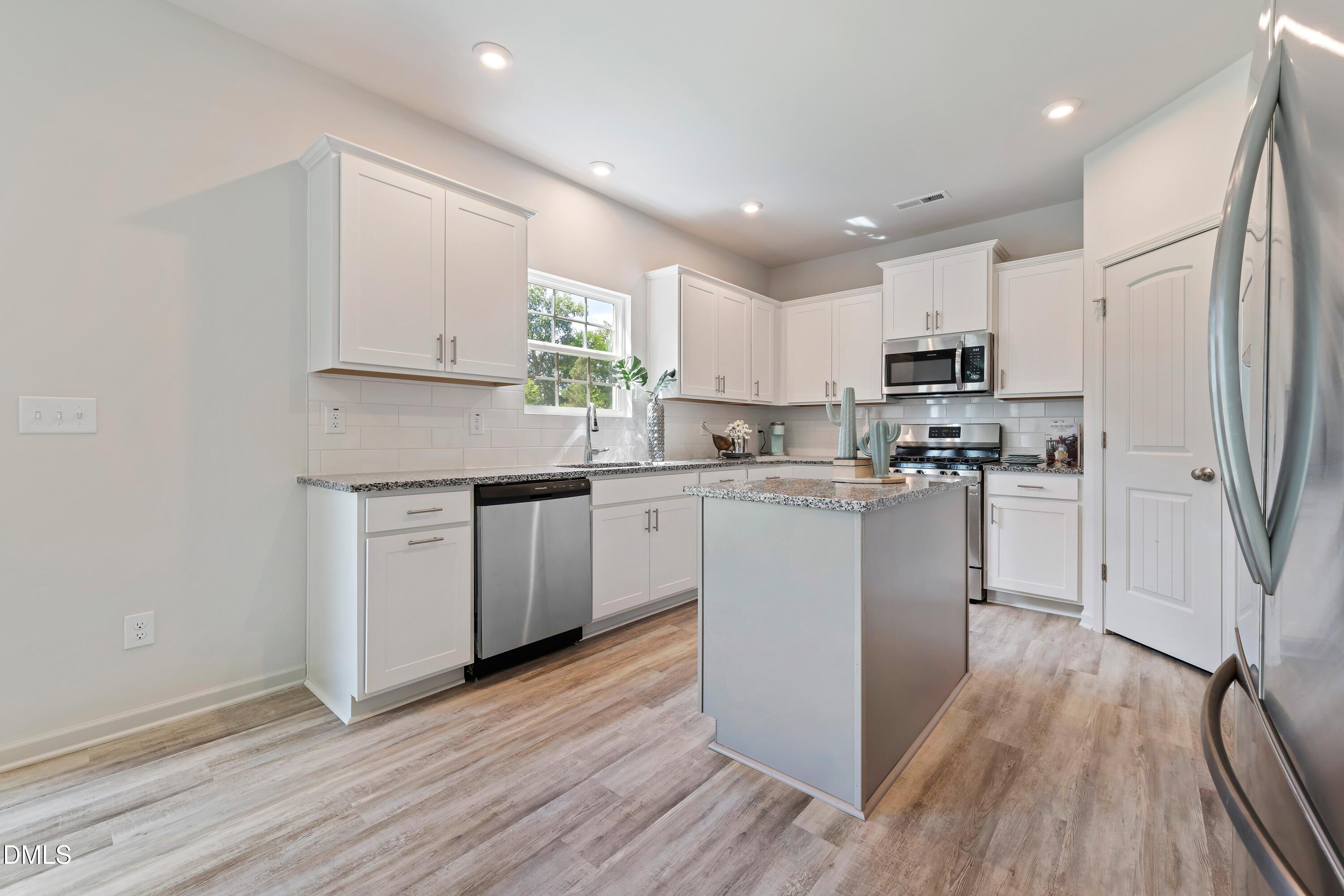 124 Starlet Ridge Way Clayton, NC 27520 - Photo 13 of 36 a kitchen with cabinets wooden floor and a sink