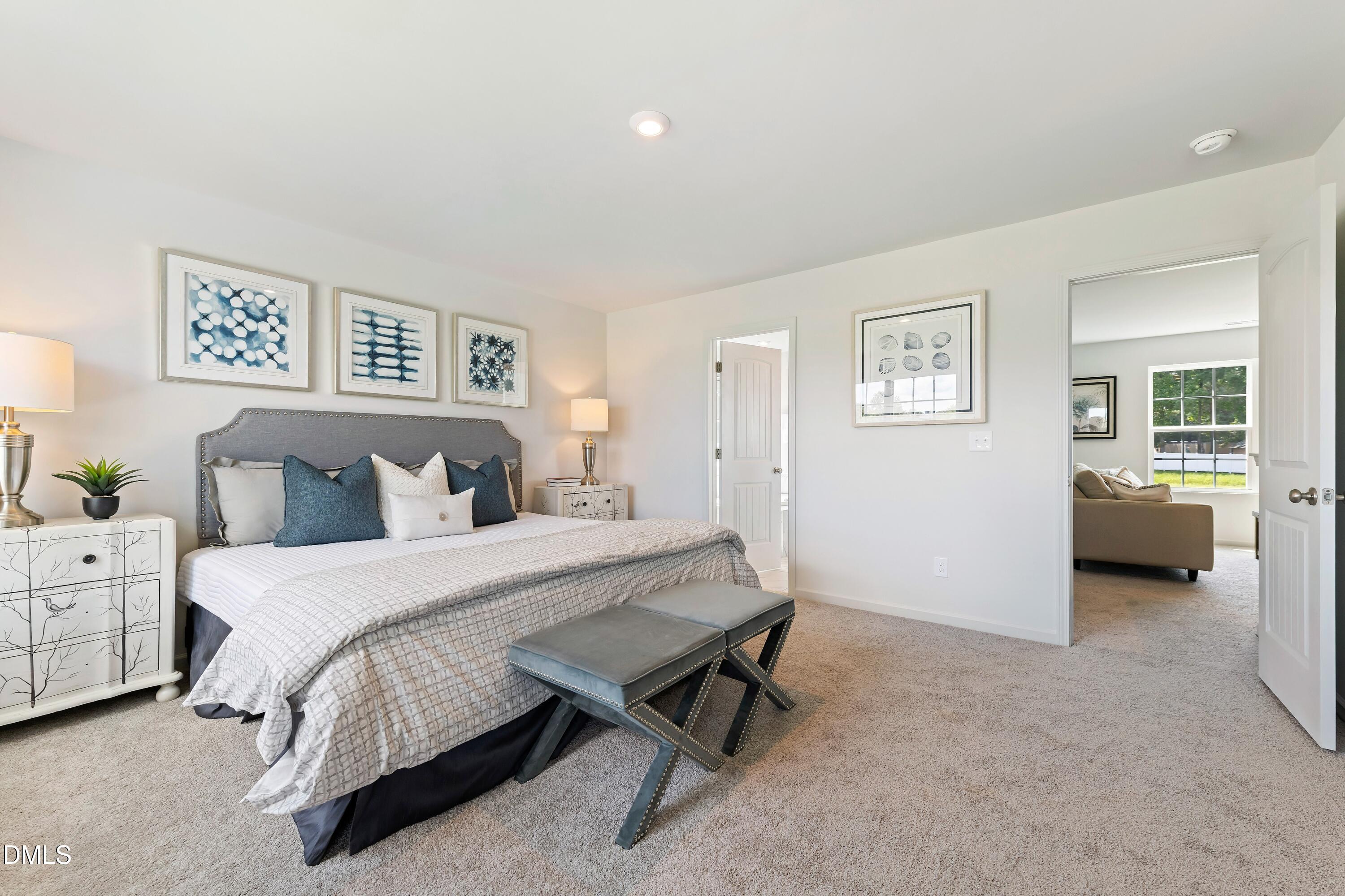 124 Starlet Ridge Way Clayton, NC 27520 - Photo 27 of 36 a spacious bedroom with a bed and a couch