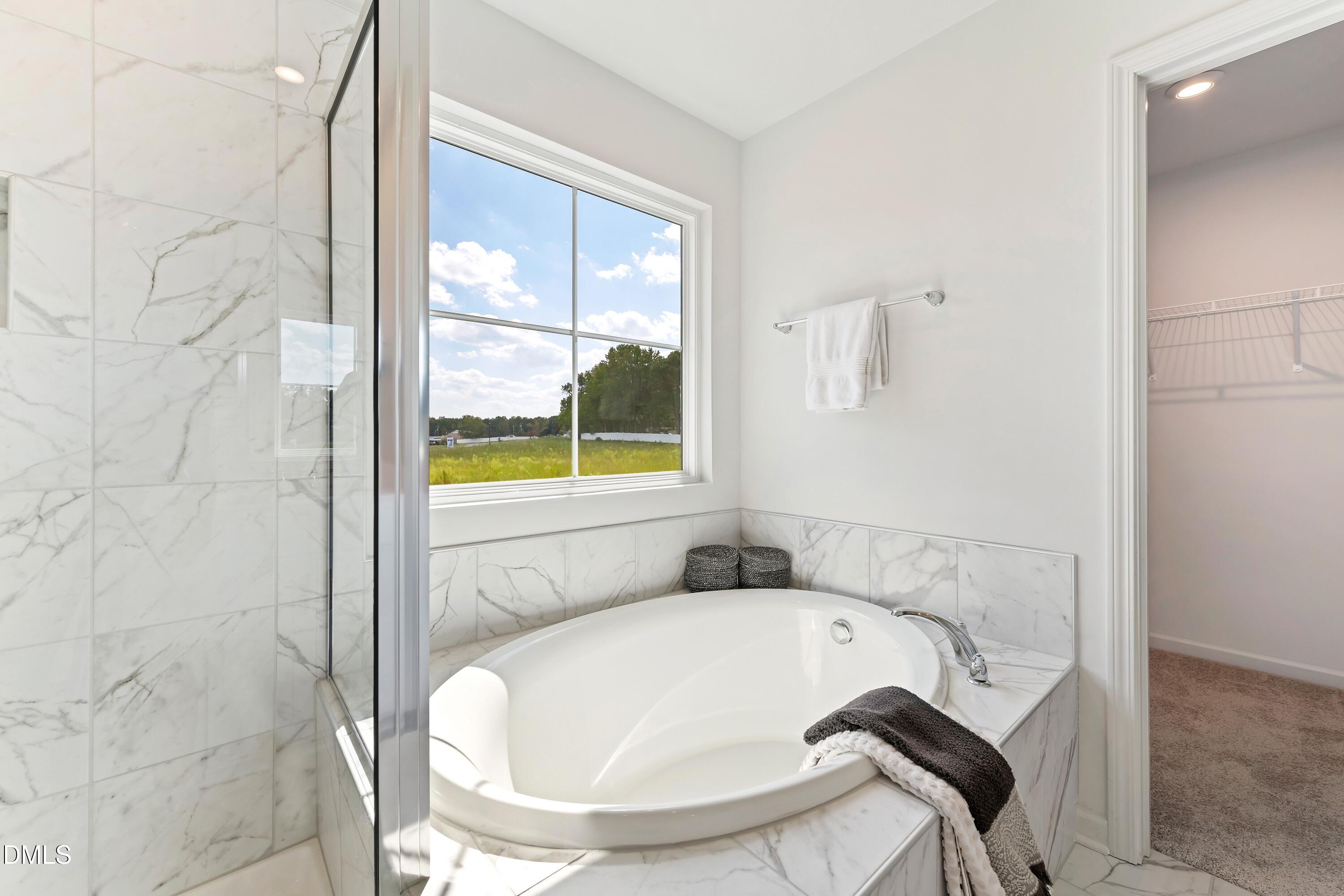 124 Starlet Ridge Way Clayton, NC 27520 - Photo 31 of 36 a bathroom with a tub and shower