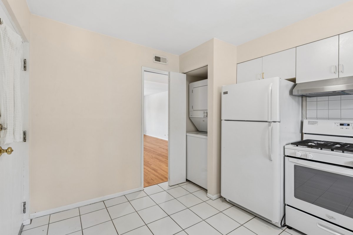 140 Green Bay Road, Unit 2 Glencoe, IL 60022 - Photo 9 of 28 a view of a kitchen with refrigerator and white cabinets