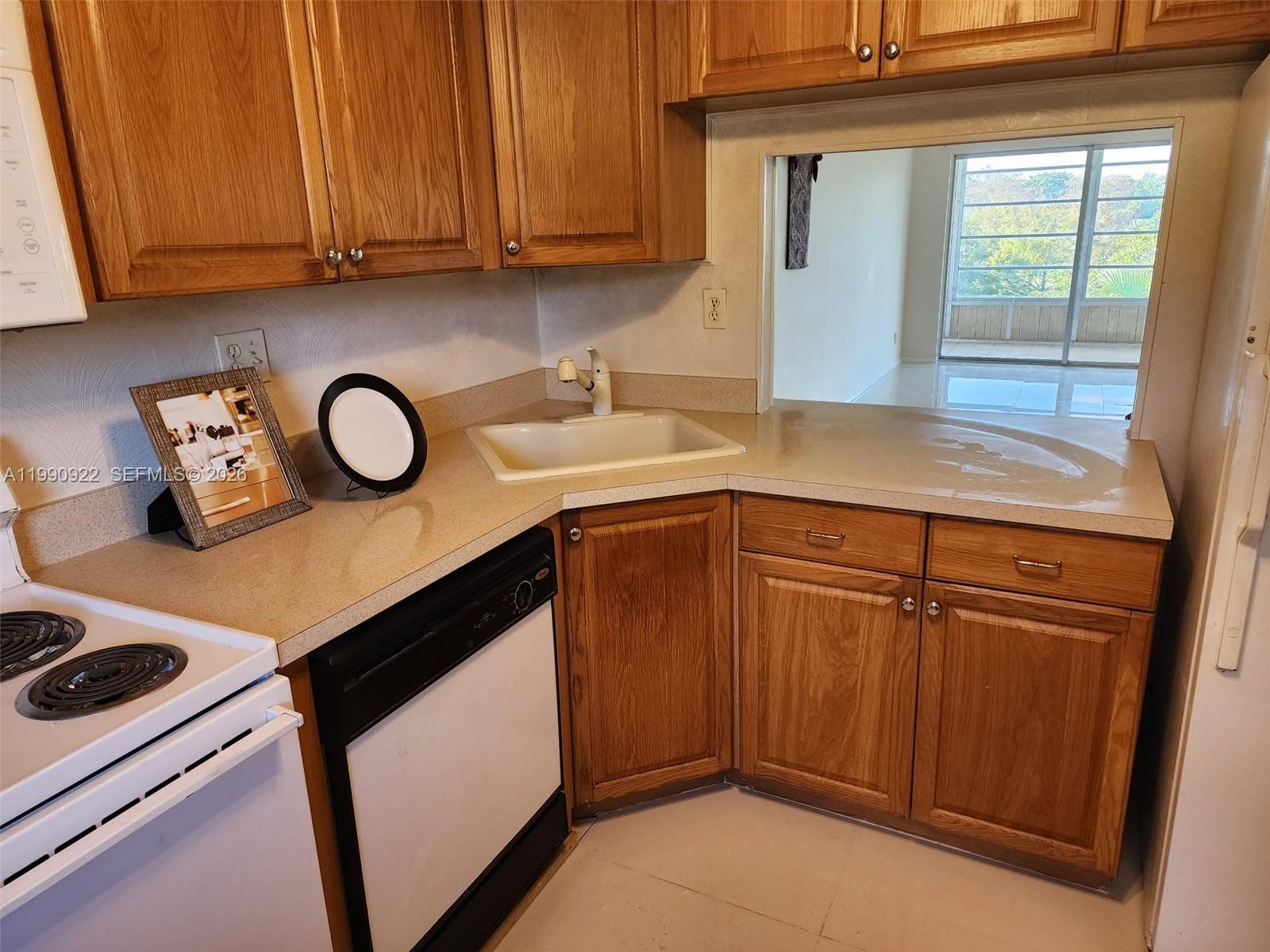 8370 Sands Point Boulevard, Unit H303 Tamarac, FL 33321 - Photo 3 of 7 a kitchen with stainless steel appliances granite countertop a sink stove and cabinets