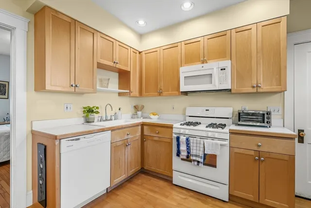 a kitchen with stainless steel appliances granite countertop a sink and cabinets with wooden floors