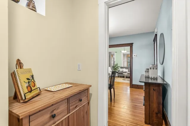 a view of a hallway with wooden floor and a bathroom