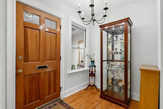 a view of a hallway with a door and wooden floor