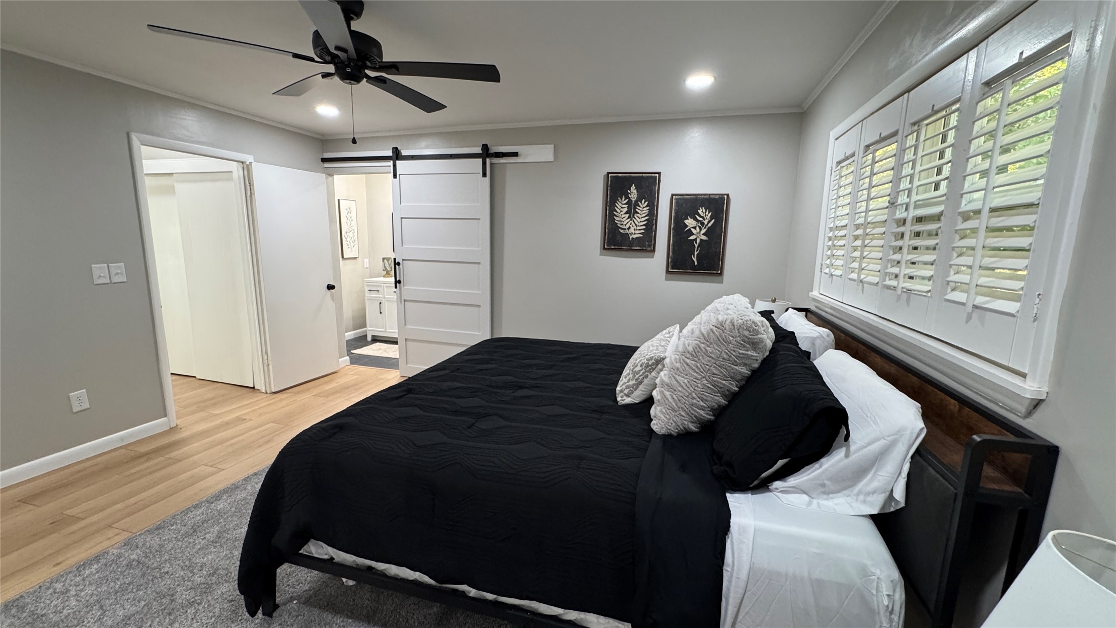96358 South 4531 Road Vian, OK 74962 - Photo 34 of 58 Wood-finish flooring, recessed lighting, ceiling fan, white plantation shutters, and a sliding barn door with matte black hardware