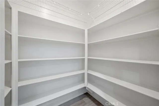 a backyard of a house with lawn chairs plants and large tree