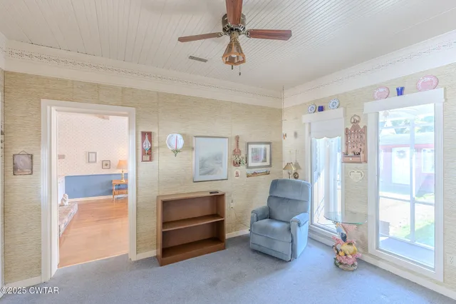 a living room with furniture and a ceiling fan