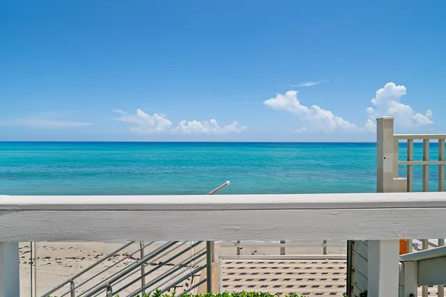 a large white kitchen with a large counter top space and stainless steel appliances