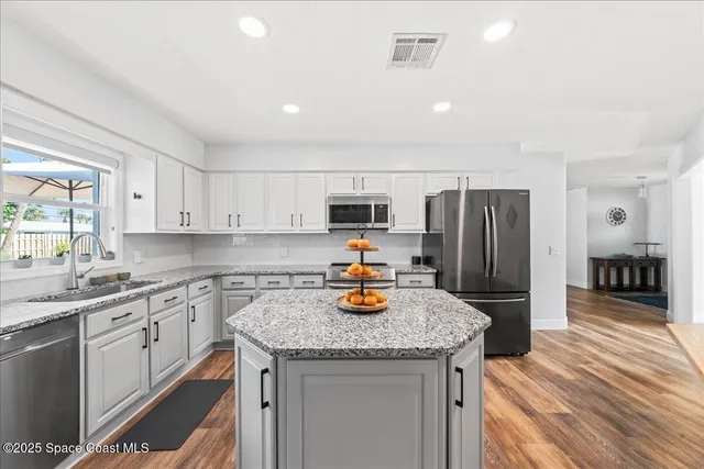 a kitchen with stainless steel appliances granite countertop a sink stove and refrigerator