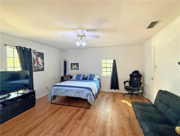 a living room with a bed furniture and a flat screen tv