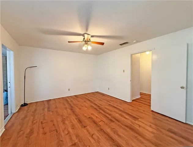 a view of an empty room with a chandelier fan