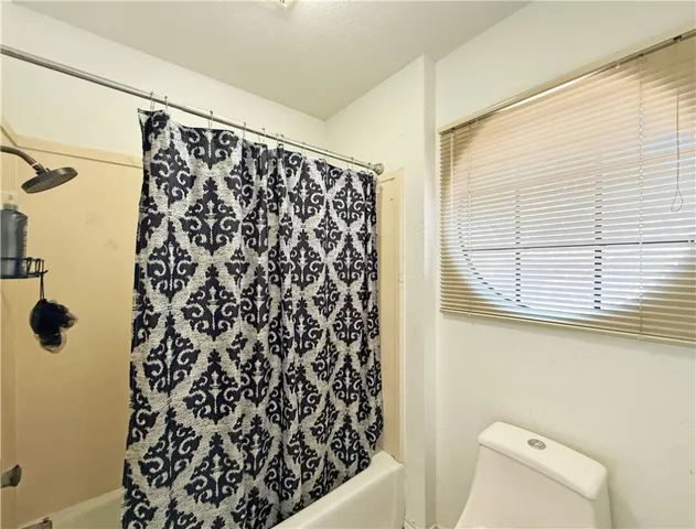 a bathroom with a shower curtain and a window