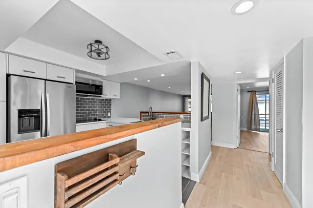a view of kitchen with refrigerator and window