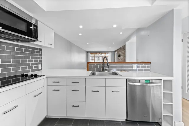 a kitchen with granite countertop a sink a stove and cabinets