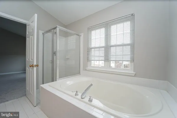 a white bath tub sitting in a bathroom next to a window